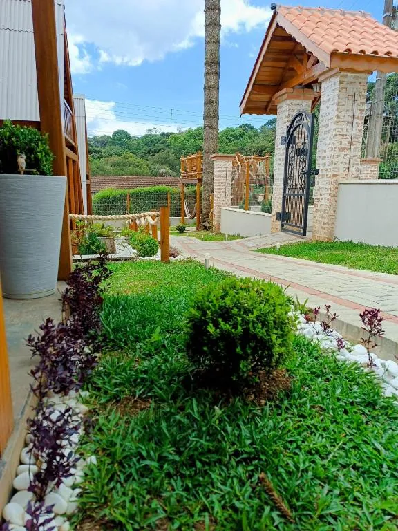 Jardim com gramado e portão de entrada